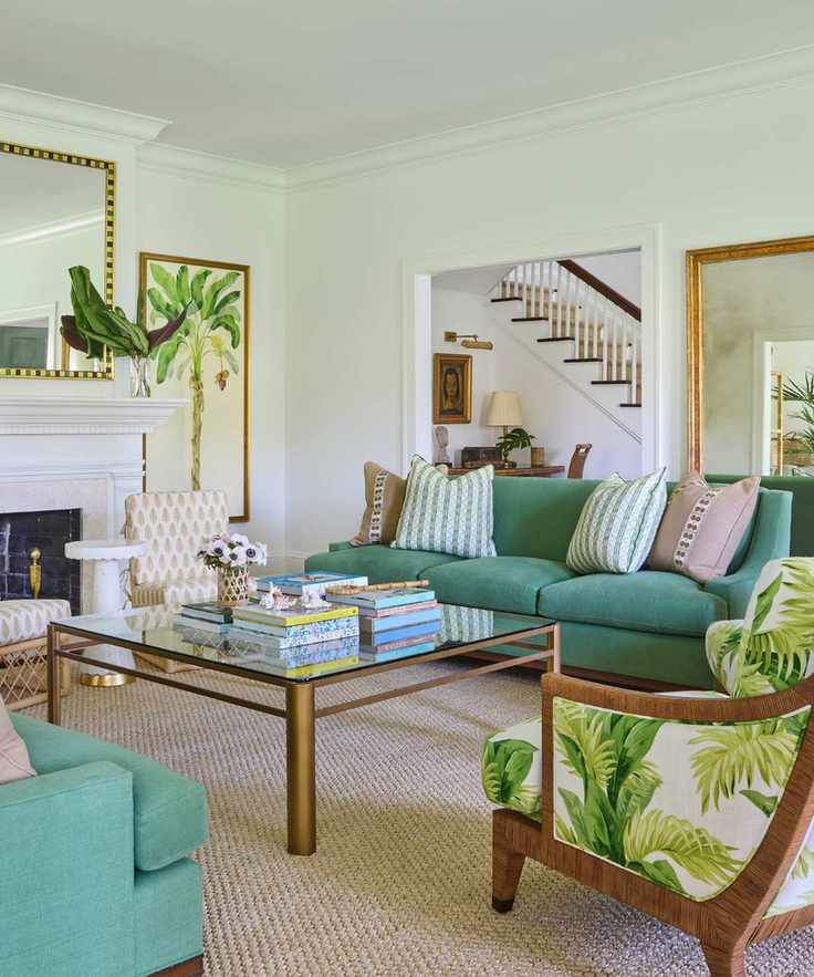 warm vs cool colors, green and white/neutral living room with botanical prints, mirrors, two green couches, botanical print upholstered armchair