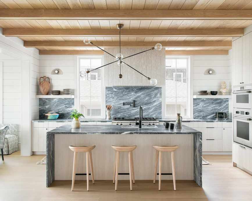 A kitchen with a green marble backsplash and island countertop, showcasing white kitchen backsplash ideas.