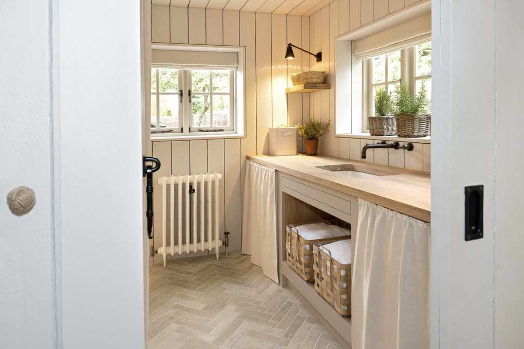 Narrow utility room with herringbone flooring and fabric drapes