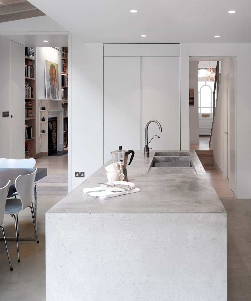 Contemporary kitchen showcasing a concrete island and open layout