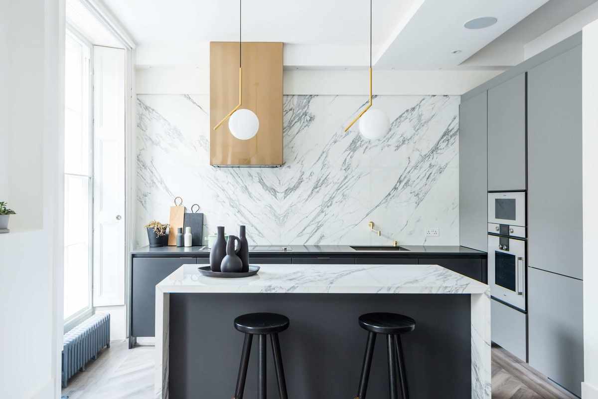 White kitchen ideas with black and marble kitchen island and marble backsplash.
