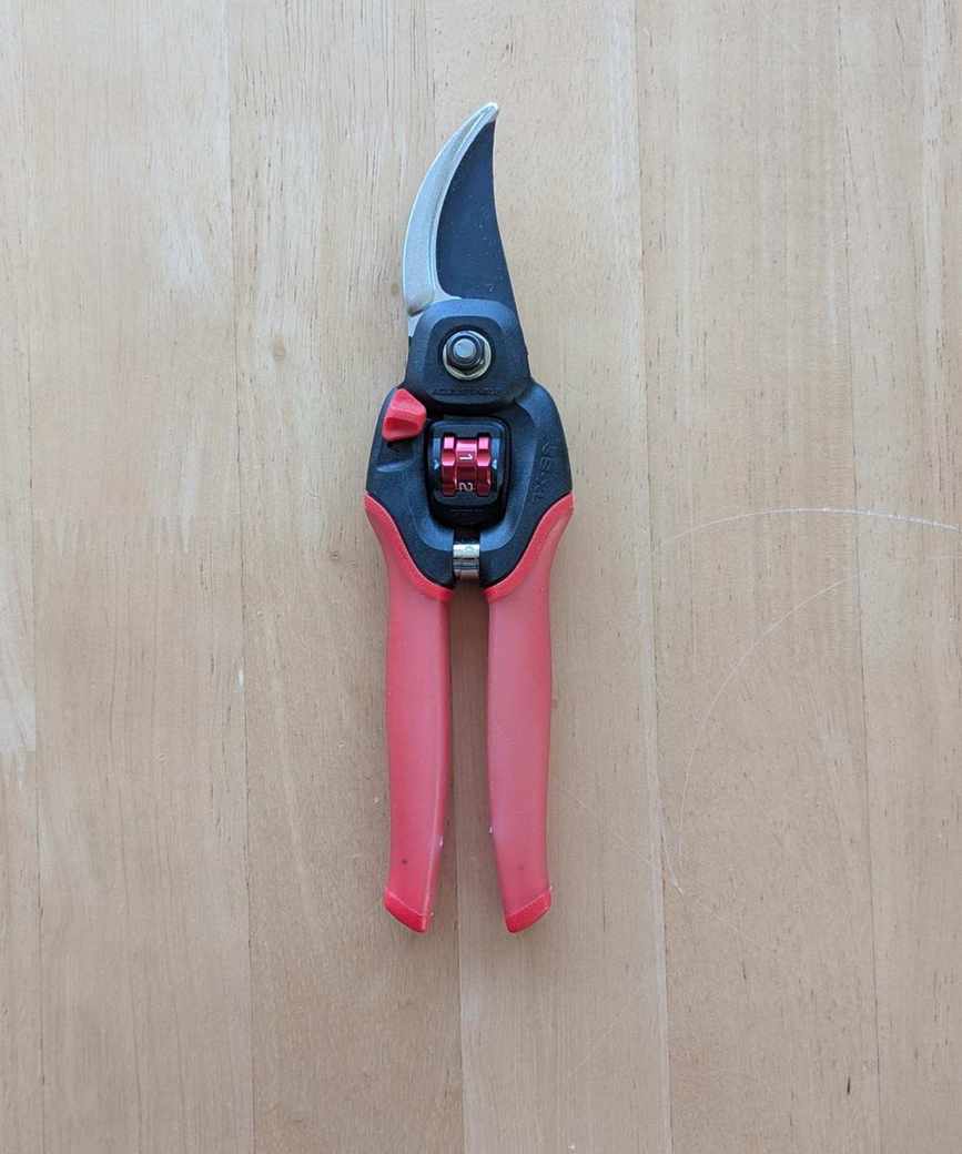 A pair of Corona FlexDIAL ComfortGEL Bypass Pruners on a wooden table