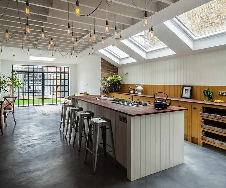 A spacious kitchen extension featuring glazed roof panels and a large island