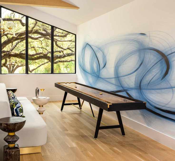 games room with table game, blue swirl on wall, couch, side tables, wooden floor