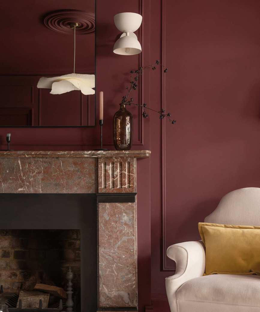 A living room adorned with deep red walls and marble accents.