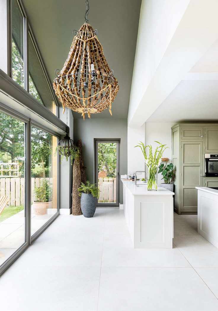 kitchen wall with full height gable end glass window wall and pale gray green painted wall and ceiling kitchen sink set in white worktop