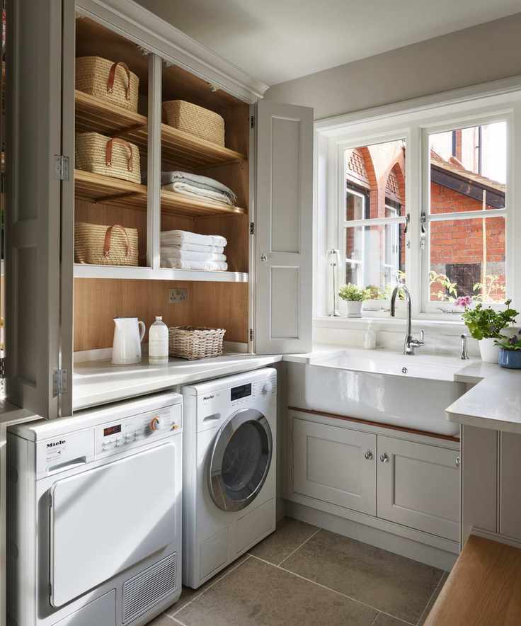 Small laundry room with bifold doors and a butler sink, showcasing a practical layout.