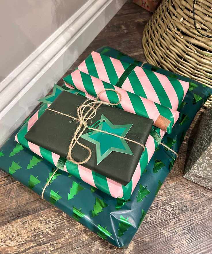Colorful green and pink Christmas wrapping with green star and brown ribbon