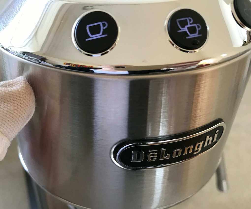 De'Longhi Dedica Arte controls and stainless steel being wiped down