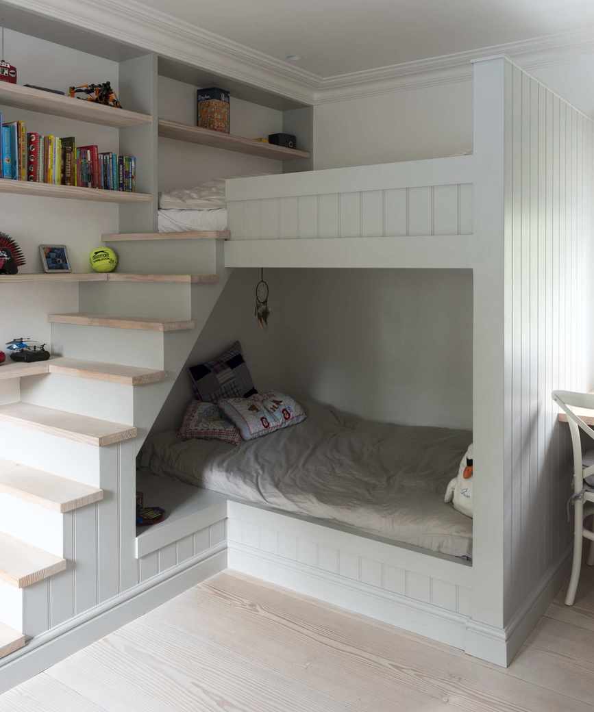 A gray loft bed featuring a staircase and lower bunk