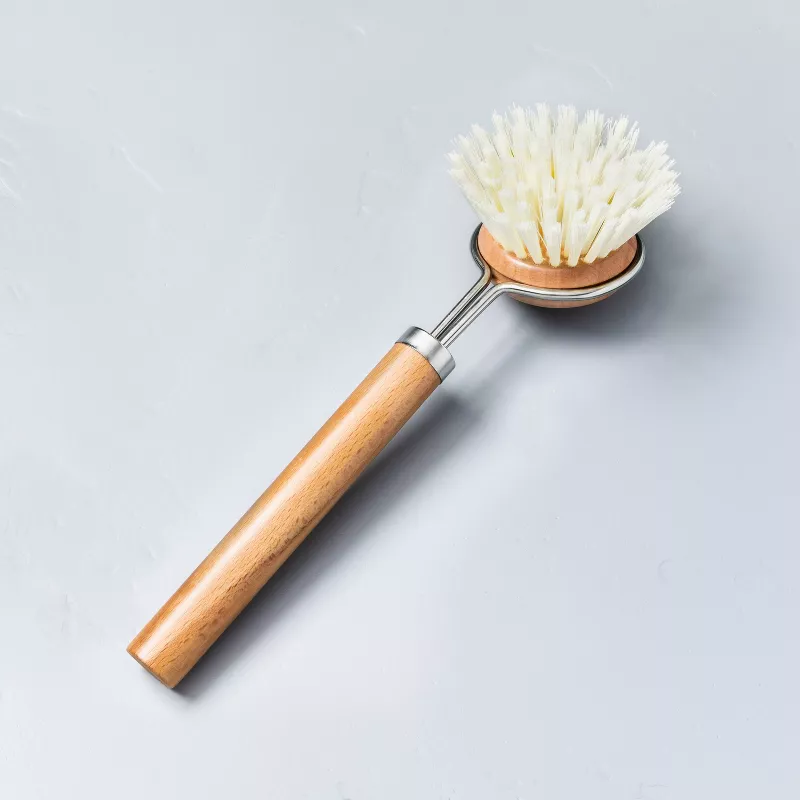 A wooden handled dish scrubbing brush with nylon bristles