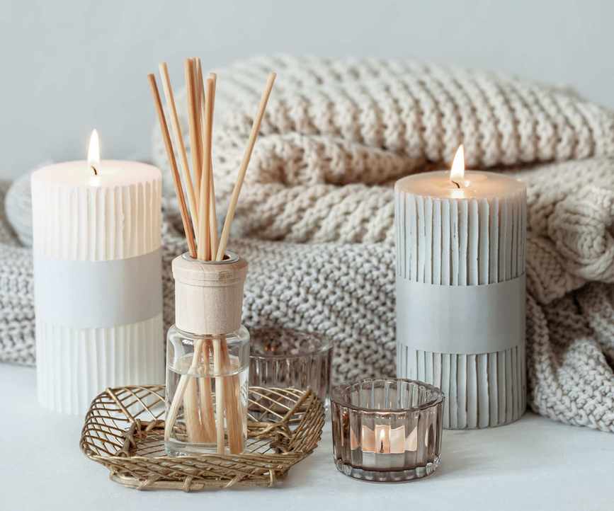 candle and diffuser with blankets in the background
