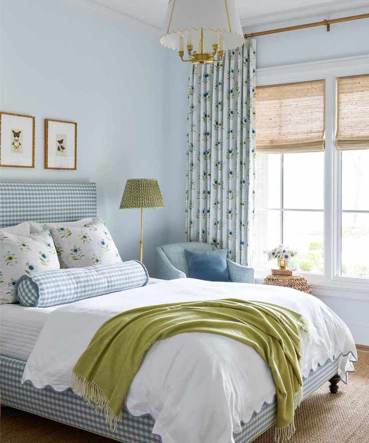 Pale blue bedroom with a green throw and lampshade by Katie Davis Design
