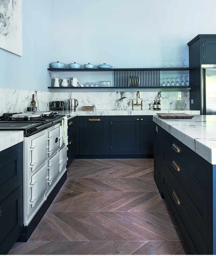 Kitchen flooring ideas in a blue and marble kitchen with herringbone wood flooring.