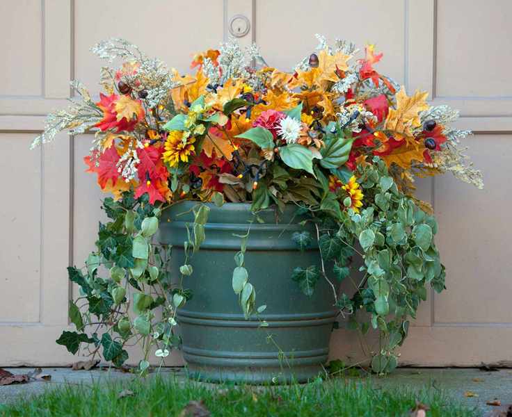 Colorful winter container with lights, fake leaves, green plants