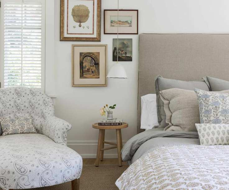 bedhead and armchair chaise and rustic stool with soft pastel colors and wooden floors