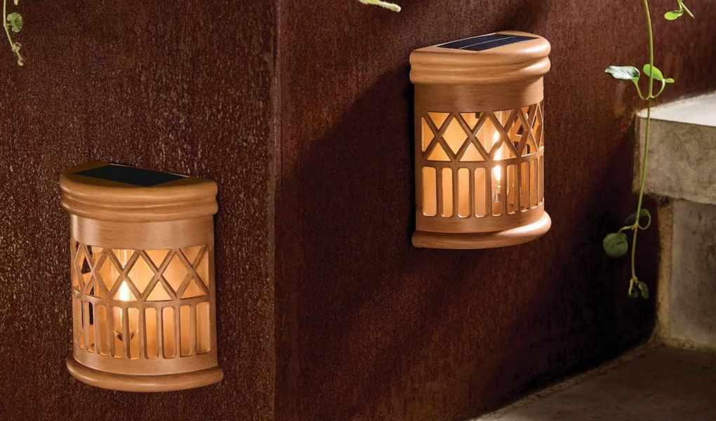 Woven solar outdoor fence lamps affixed to a terracotta patio wall 