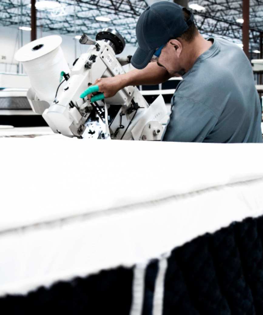 A worker operating a machine in the 3Z mattress factory.