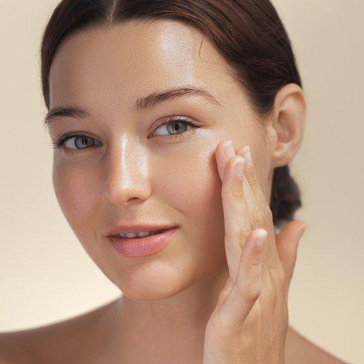 Image of model applying face product to her face