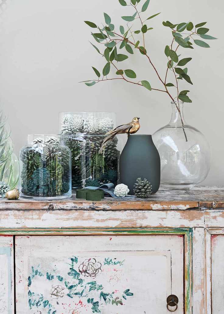 Sprayed pine cones displayed in vases