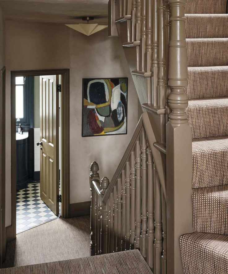 an earthy limewashed entryway and staircase in a Victorian home