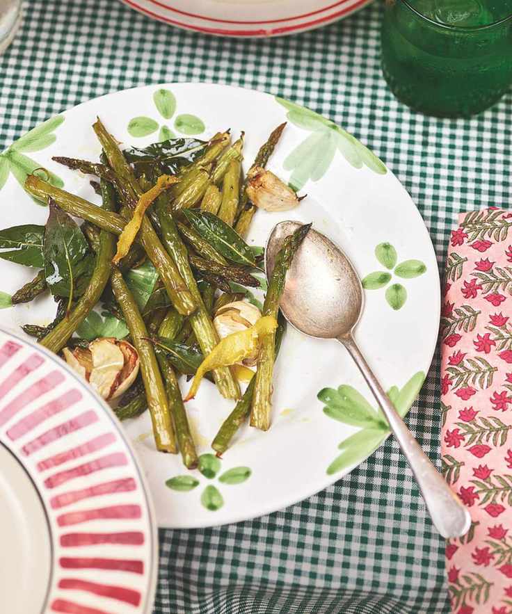 Asparagus adorned with bay leaves and garlic on a decorated plate