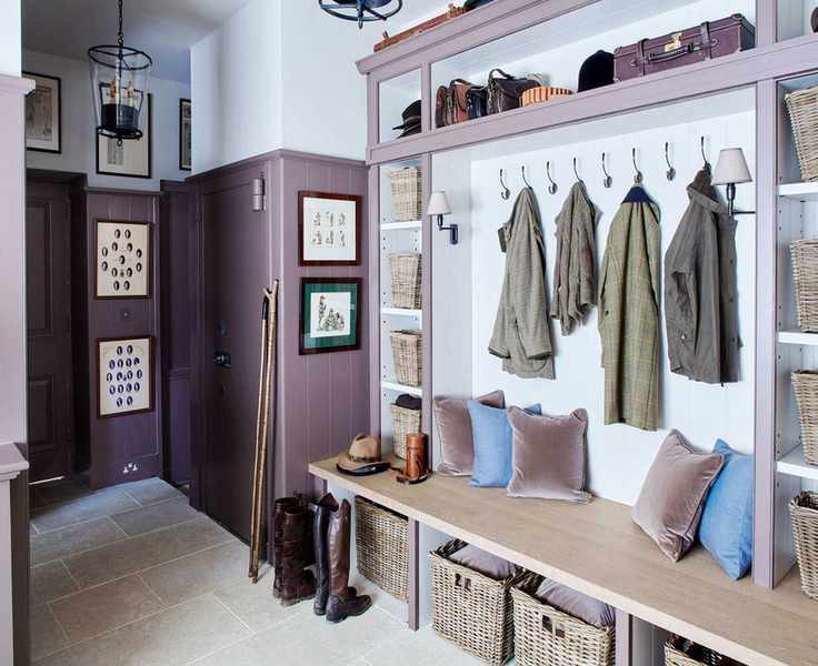 An example of mudroom ideas showing a purple mudroom with wall paneling, wicker baskets and a bench with cushions