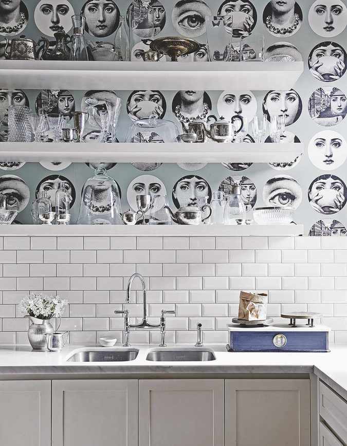 Patterned wallpaper behind shelves above white tiles.
