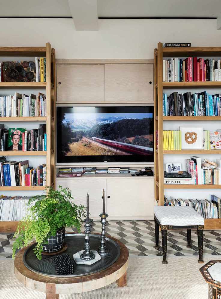TV room with bookcase built around a central TV on a cream wall