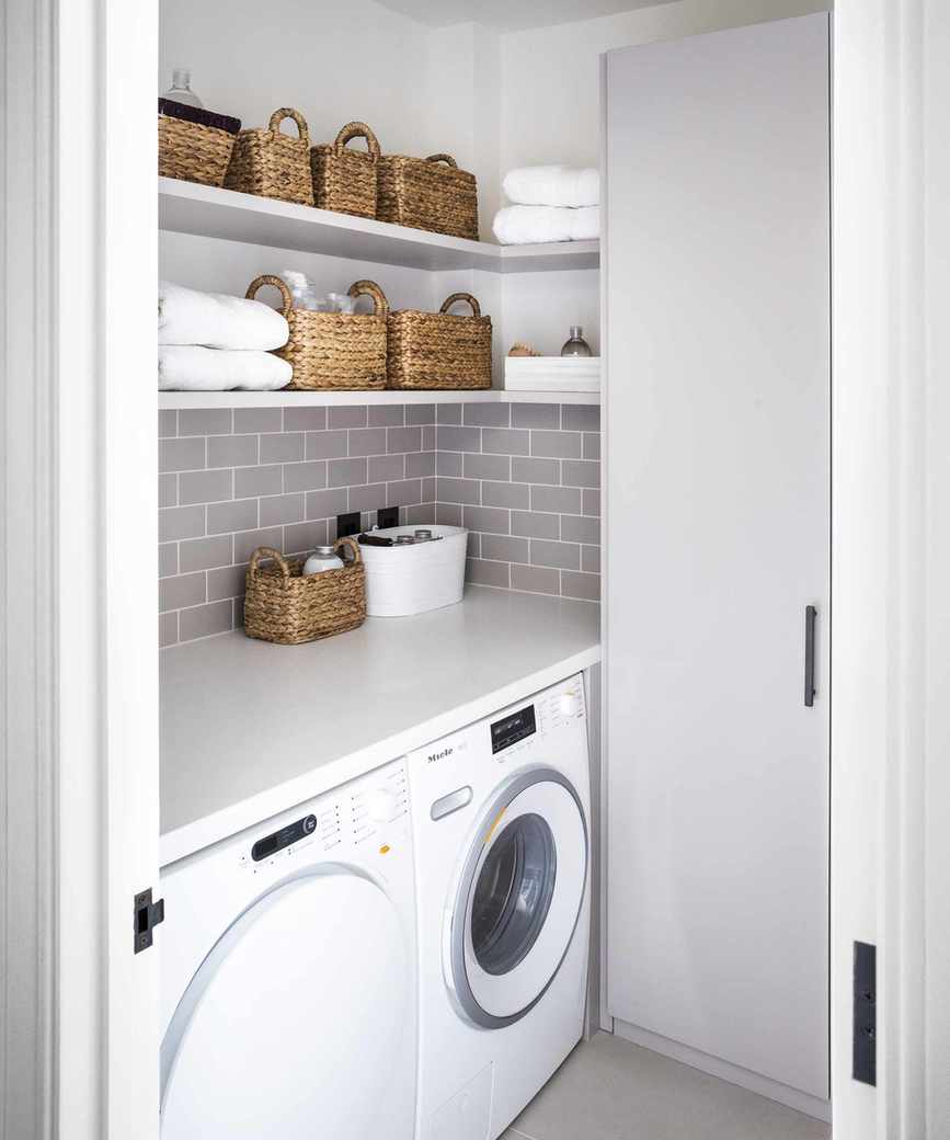 Laundry room with wall-mounted shelving for organized towel storage.