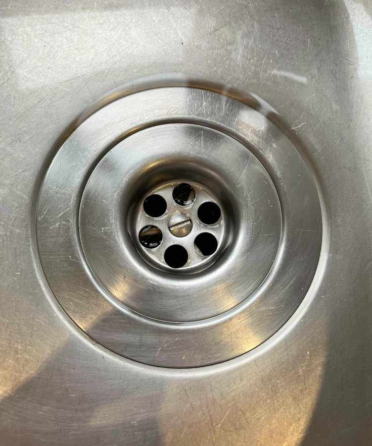 Close up of clean stainless steel sink drain with no more tea and coffee stains