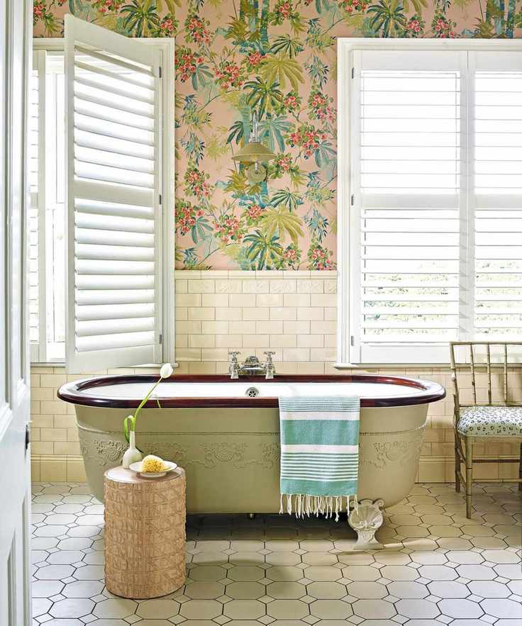 Bathroom with pale green freestanding bath and pale green wallpaper