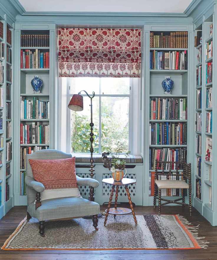 A cozy living room with bookshelves and a blue upholstered chair.