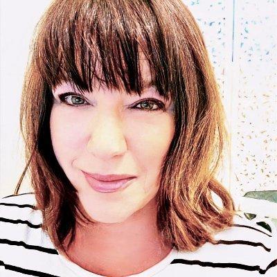 a headshot photo of astrologer Jessica Adams: a lady with a medium brown bob in a white shirt with black horizontal stripes