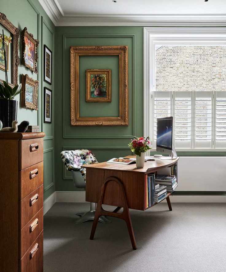 Home office with vintage desk and filing cabinet, neutral floor and green walls