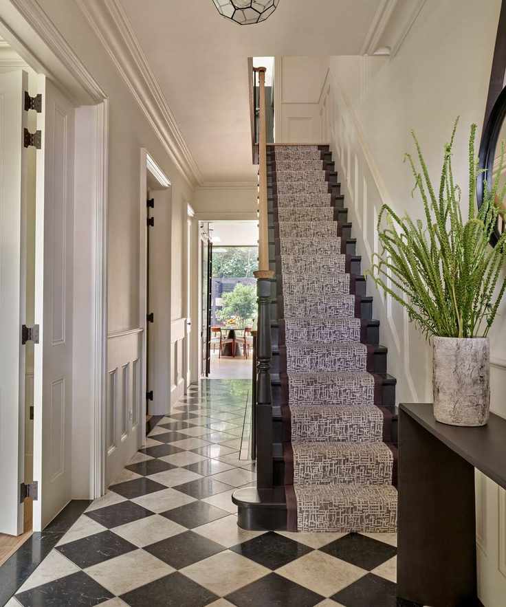 Entryway with checkered board flooring and stairs painted in dark paint