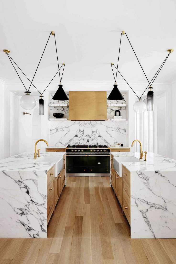 kitchen with marble surfaces and double islands with matching Belfast sinks with contemporary pendant lighting above and range cooker