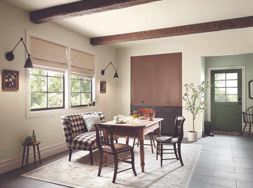 Bright entryway and breakfast nook with wooden chairs and a rug