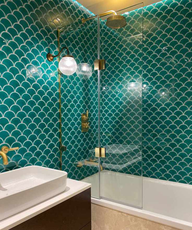 Elegant bathroom with scalloped wall tiles and brass fixtures