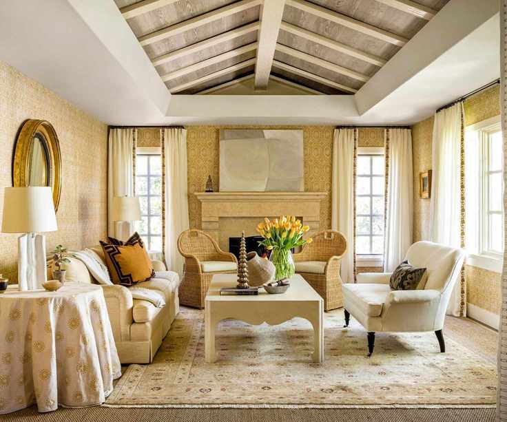 yellow living room with textured wallcovering and vaulted ceiling with rattan chairs and white sofa