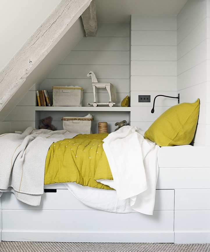 Small bedroom storage ideas integrated into a white nook.