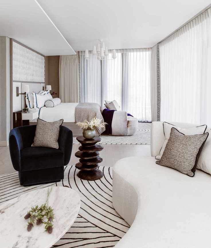 Bedroom with seating area with couch and armchair in neutral and blue