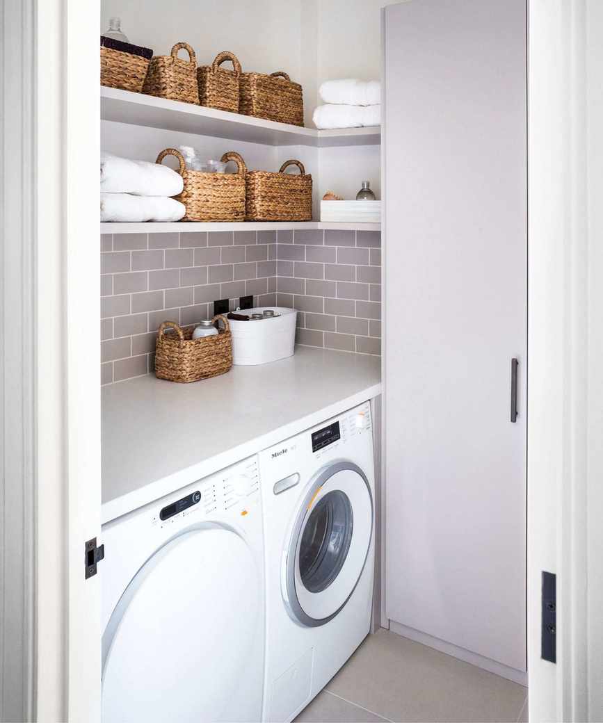A tidy purple tiled laundry room with washing machine and dryer