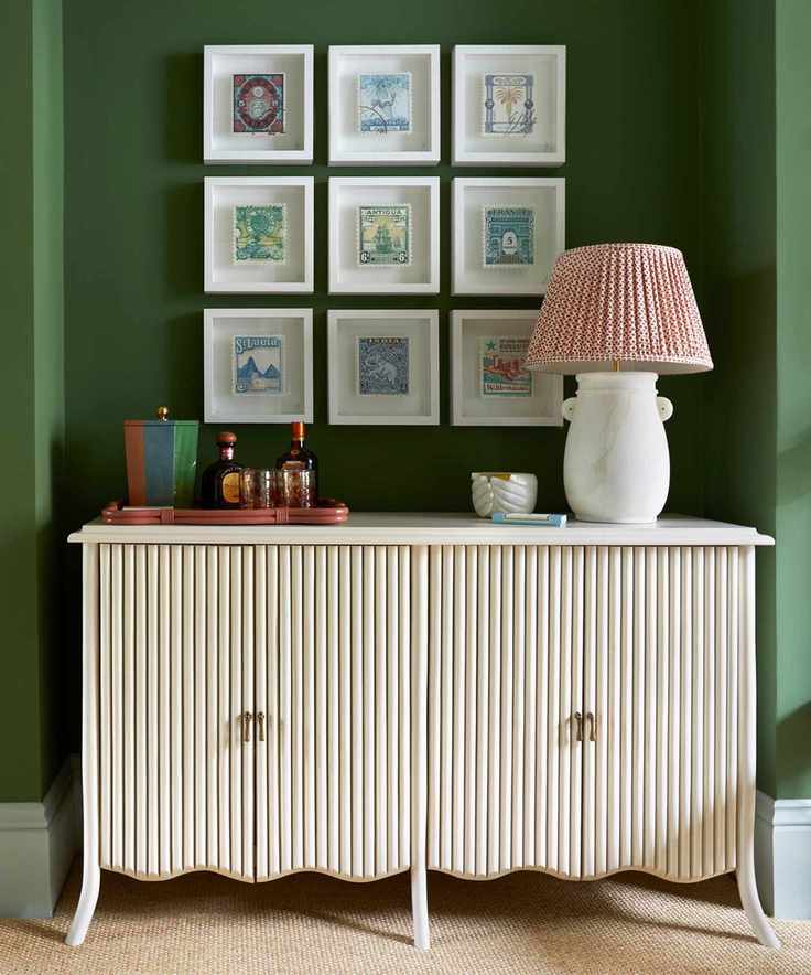 green living room with white storage cabinet and gallery wall of art