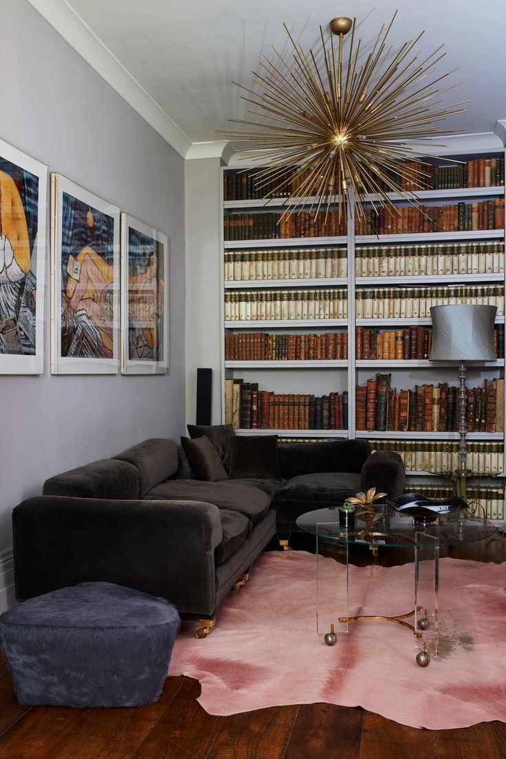 Pink mock cow hide rug, bookshelf to the ceiling and spiked chandelier
