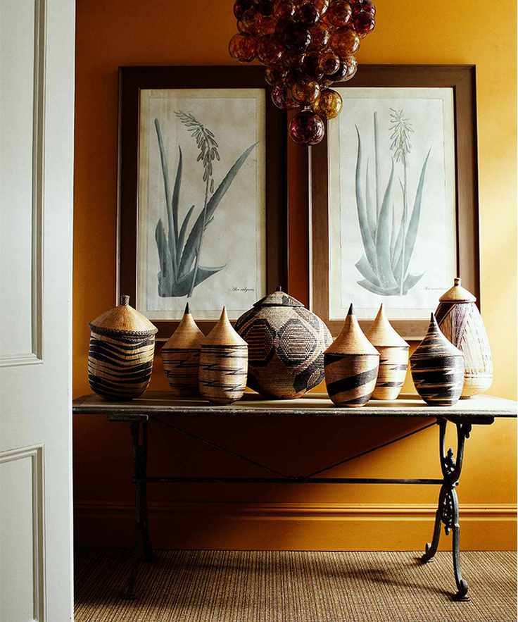 mustard yellow painted hallway with console table with wall art and vases
