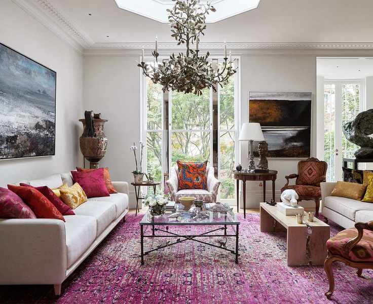 A chandelier in a grand scheme with red oriental rug demonstrating small living room lighting ideas.