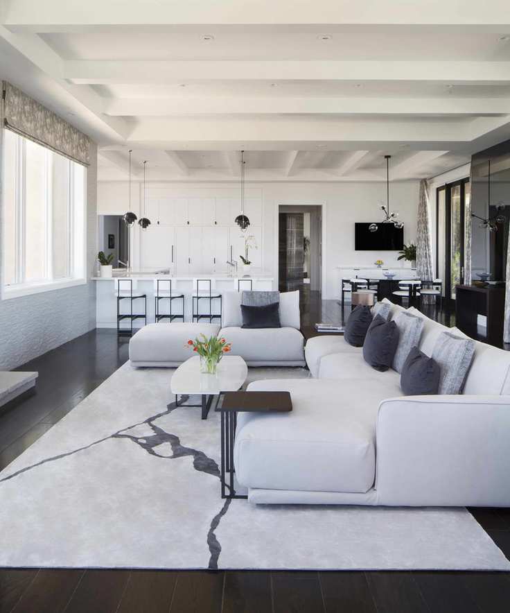 A white family room in an open-plan living and kitchen space