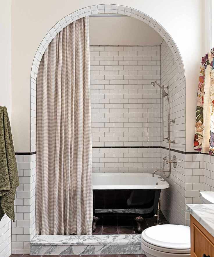 Modern white bathroom with freestanding tub and arched alcove
