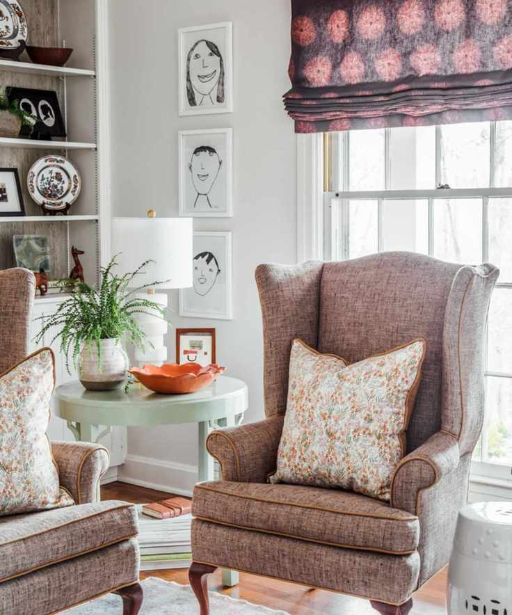 living room with armchair and children's self portrait art displayed